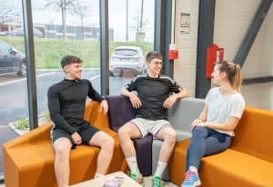 3 étudiants assis sur un canapé en train de parler, moment de détente entre apprenants de l'ENCP de Caen