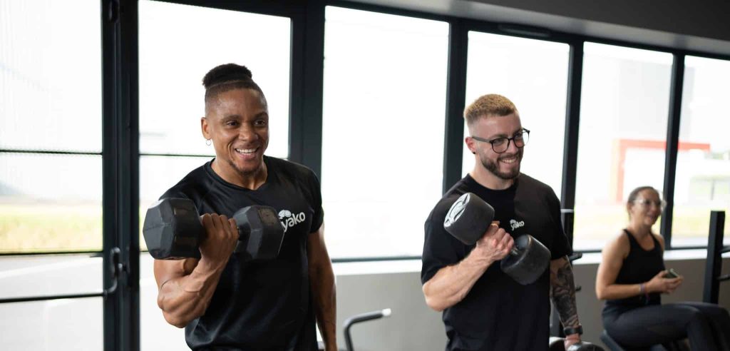 Deux coachs en train de faire des curls avec une altère